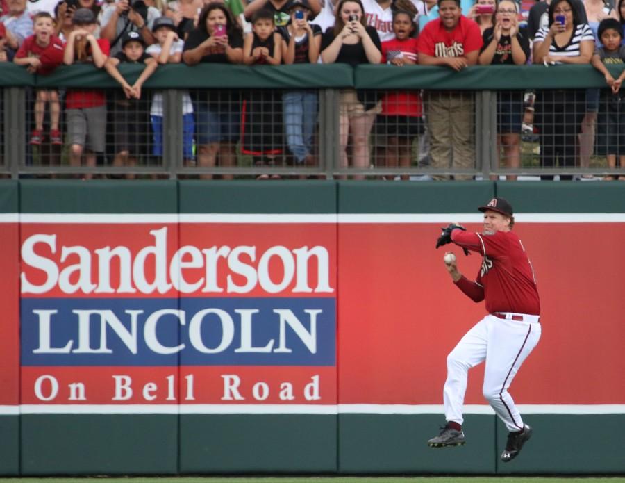 Will Ferrell prepares to make a throw from left field as fans look on.