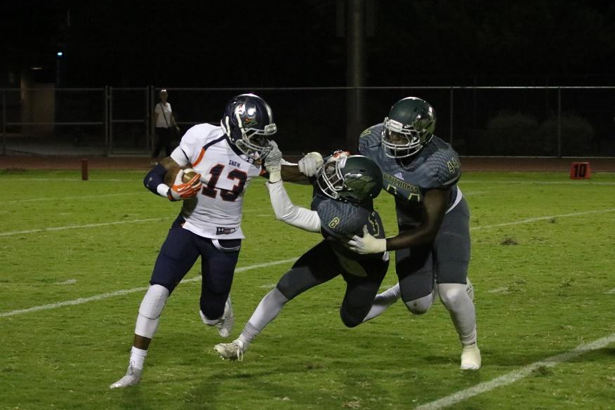 Snow College wide receiver Calief Samon (13) stiff arms cornerback Telvince Way (8) as defensive end Kisima Jagne (44) looks on in Snow Colleges 31-14 win over Scottsdale on Sept. 19.