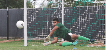 Freshman goalkeeper Luis Hector Hernandez dives and blocks a potential goal during practice. 