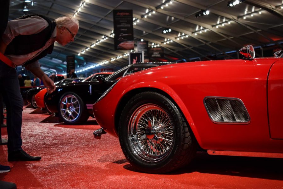 A prospective buyer inspects one of the collector cars for auction