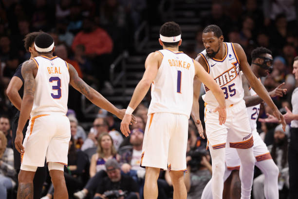 Kevin Durant #35 of the Phoenix Suns high fives Bradley Beal #3 and Devin Booker #1 during the second half of the NBA game against the Brooklyn Nets at Footprint Center on December 13, 2023 in Phoenix, Arizona. 