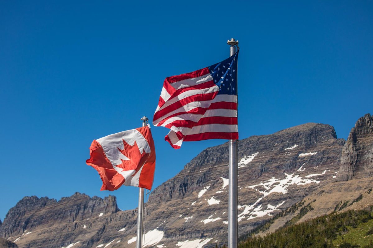US and Canadian flags flying over Logan Pass visitor center